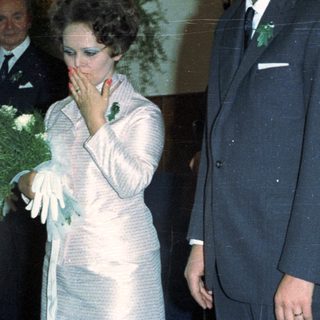 Couple and guests at an event, possibly a wedding.