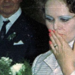 Couple and guests at an event, possibly a wedding.