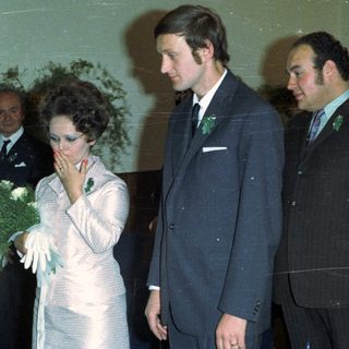 Couple and guests at an event, possibly a wedding.