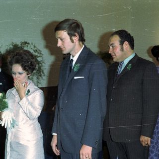 Couple and guests at an event, possibly a wedding.