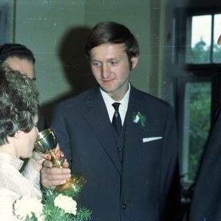 Woman holding trophy with man and others nearby.