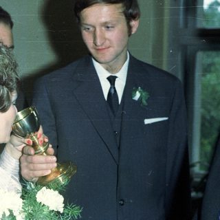 Woman holding trophy with man and others nearby.