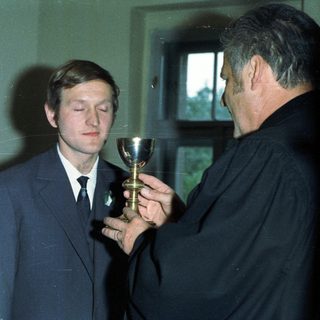 Man receiving communion from a priest, wedding scene.