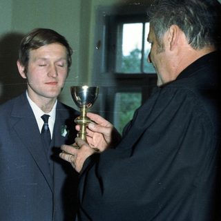 Man receiving communion from a priest, wedding scene.