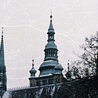 Snow-covered gothic cathedral with prominent spires and dome.