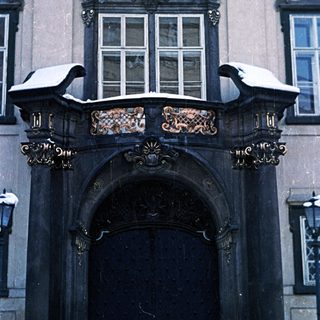 Elaborate, snow-covered doorway of a historic building.