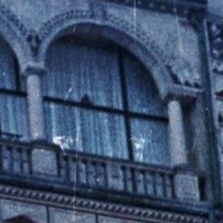 Snowy steps lead to a patterned building and stone arches.