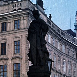 Statue and building covered in snow in a winter scene.
