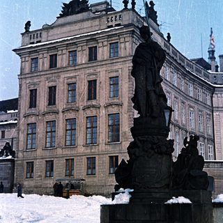 Statue and building covered in snow in a winter scene.