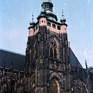 Gothic cathedral tower with clock and spire detail.