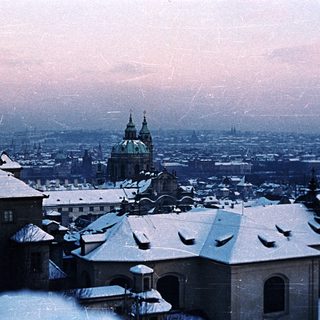 Snowy cityscape with a prominent church dome visible.