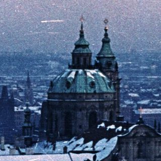 Snowy cityscape with a prominent church dome visible.