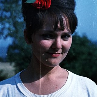 Portrait of a young woman with a red flower in her hair.