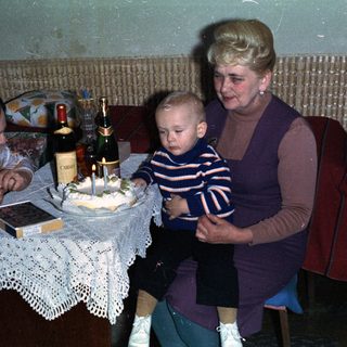 Young child with women celebrating with cake and wine.
