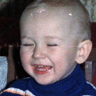 Young boy smiles while seated at a festive table.