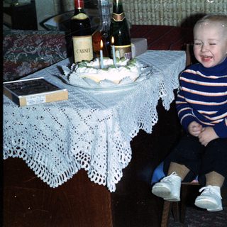 Young boy smiles while seated at a festive table.