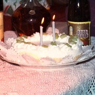 Woman and toddler near a birthday cake and wine.
