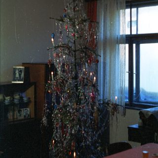 Tinsel Christmas tree in a dimly lit room.