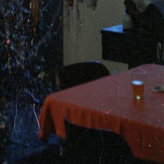 Tinsel Christmas tree in a dimly lit room.