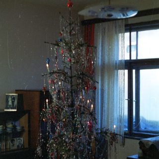 Tinsel Christmas tree in a dimly lit room.