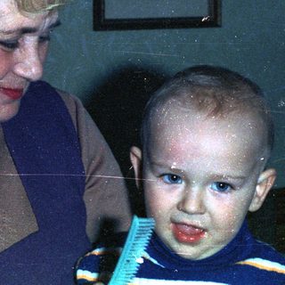 Elderly couple looking down at a young child.
