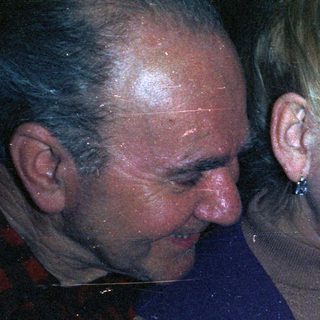 Elderly couple looking down at a young child.