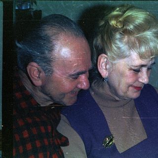 Elderly couple looking down at a young child.