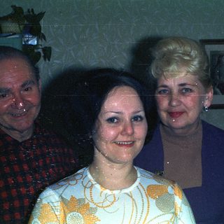 Three people posing for a photograph indoors.