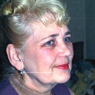 Portrait of a woman with blonde hair and red lipstick.
