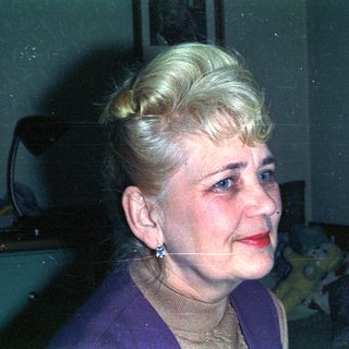 Portrait of a woman with blonde hair and red lipstick.