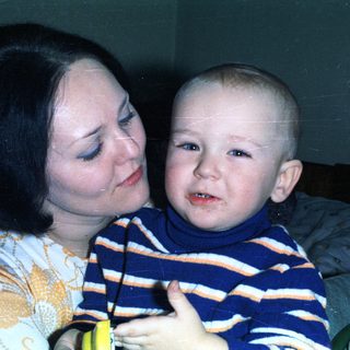 Woman embraces a young child, possibly a baby.
