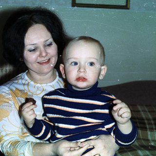 Woman holding baby, celebrating with cake and champagne.