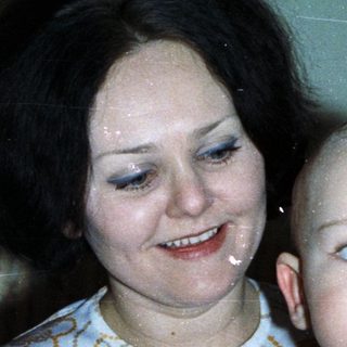 Woman holding baby, celebrating with cake and champagne.