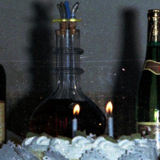 Man holding baby, celebratory scene with drinks and decorations.