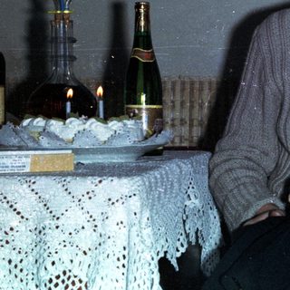 Man holding baby, celebratory scene with drinks and decorations.