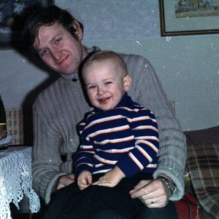 Man and child celebrating with wine and candles.