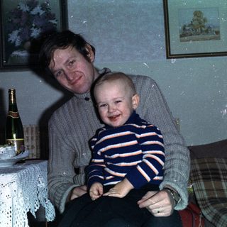 Man and child celebrating with wine and candles.