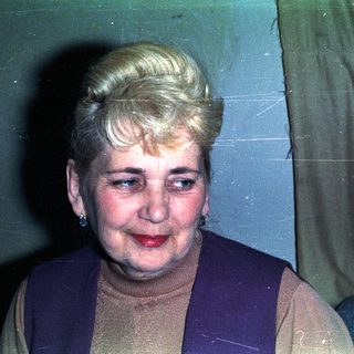 Here's a brief summary of the image: Woman with styled hair and vintage clothing indoors.