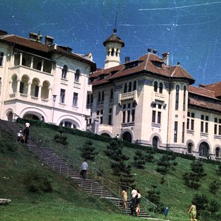 Large building on a hill with people ascending the steps.