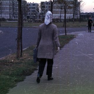 Person walks along a path with apartment buildings.