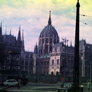Hungarian Parliament Building under scaffolding, viewed from a street.