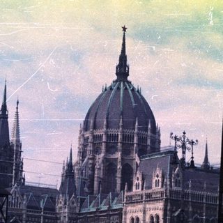 Hungarian Parliament Building under scaffolding, viewed from a street.