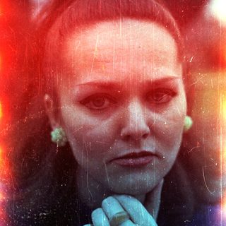 Here's a brief summary of the image: Portrait of a woman with a distressed, colorful photographic effect.