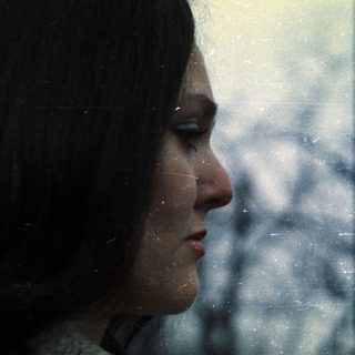 Side profile of a woman with short, dark hair.