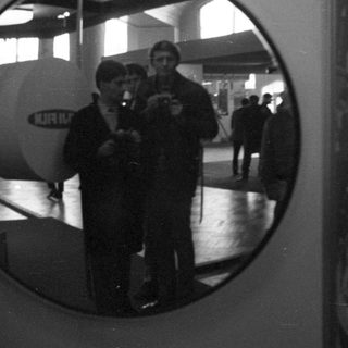 People viewed through a circular window in a building.