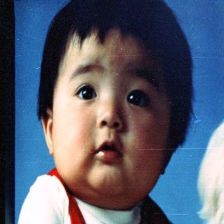 Baby and a white dog are in a portrait.
