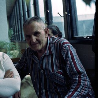 A smiling elderly couple poses for a casual portrait.