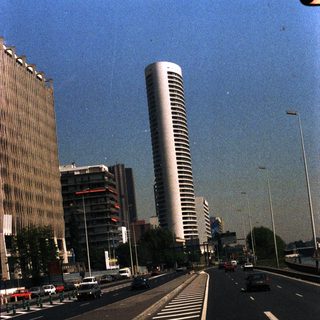 City street with tall buildings and visible traffic.