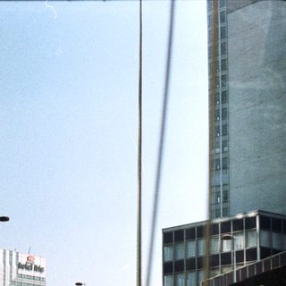 High-rise buildings seen through a highway overpass.