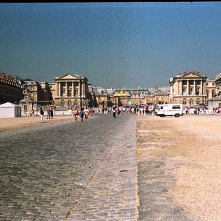 Palace of Versailles courtyard with people and buildings.